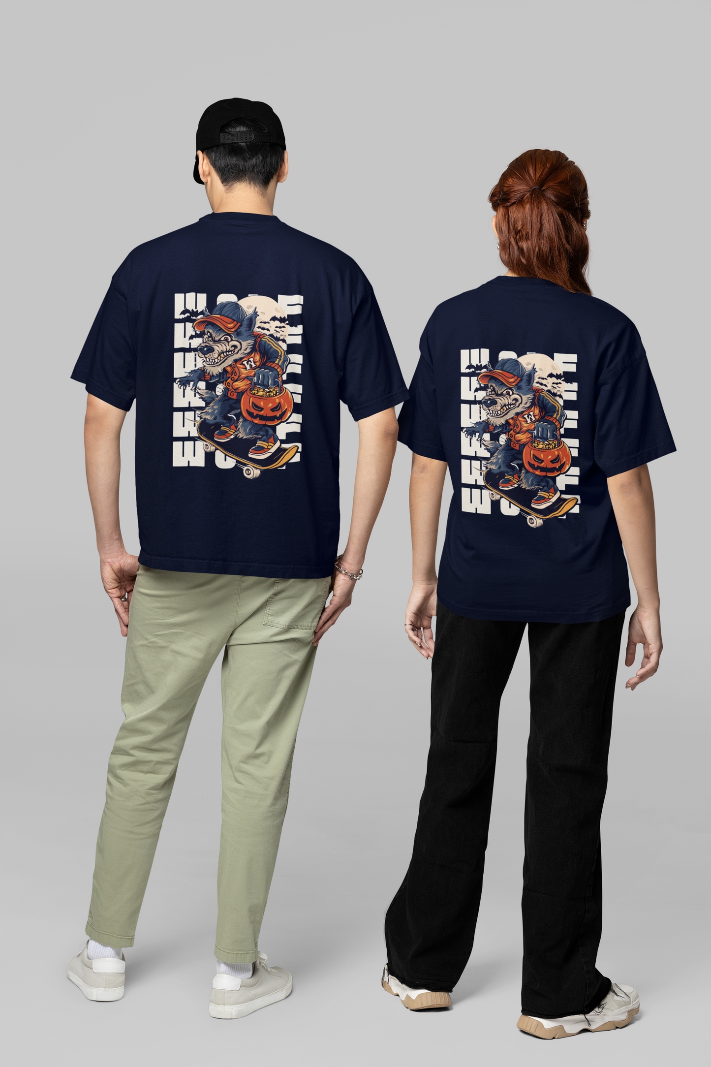 A couple wearing navy blue oversized T-shirts featuring bold 'Believer' typography on the back, showcasing a modern and edgy couple style