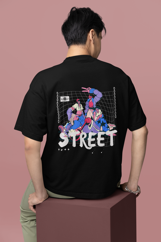 A solo man wearing a black oversized T-shirt with bold Chinese typography and a striking back graphic, showcasing edgy streetwear style on an urban street.