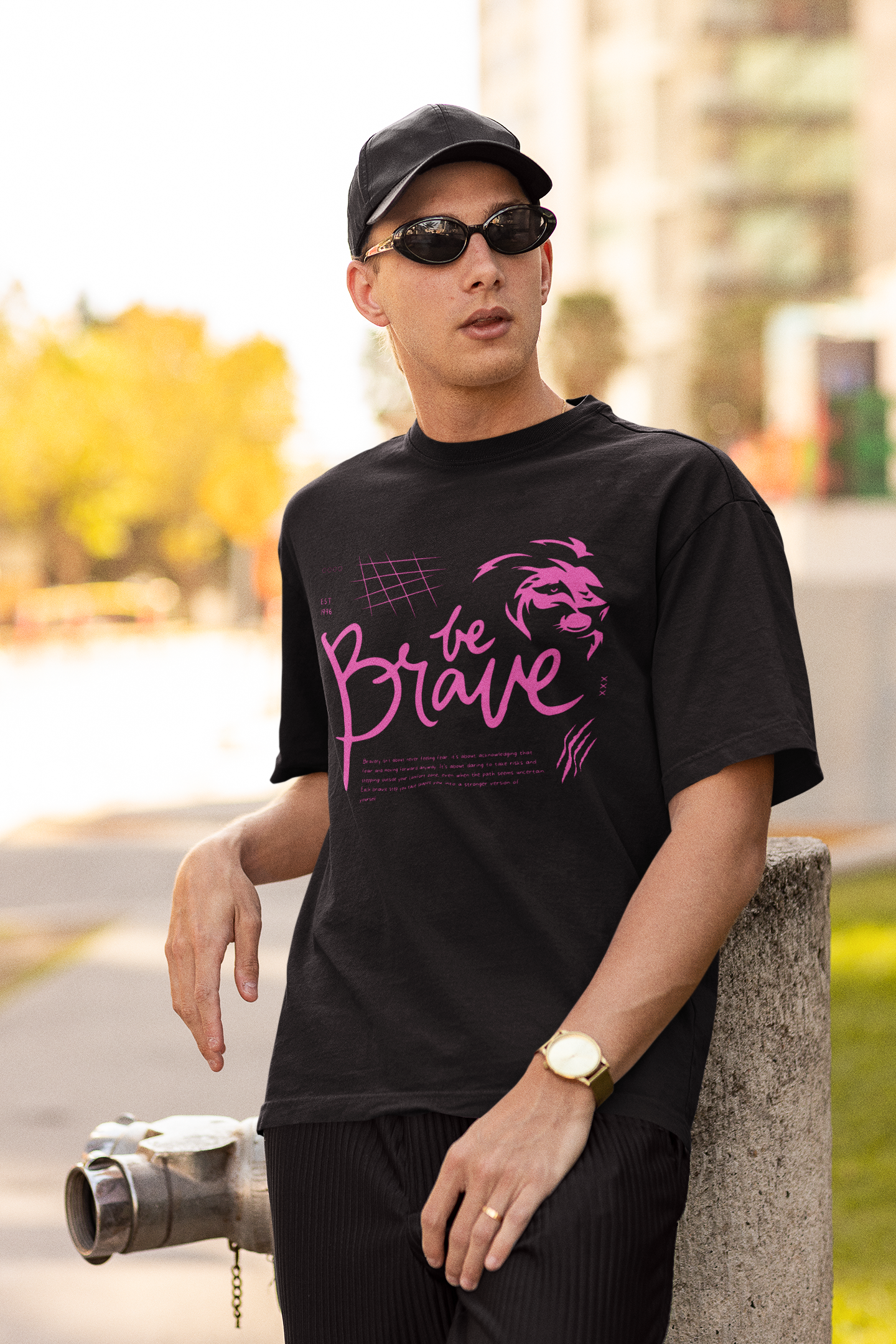 A boy wearing a black oversized T-shirt with a striking lion graphic and 'Be Brave' text on the front, showcasing fearless urban fashion by Looma Fashion.