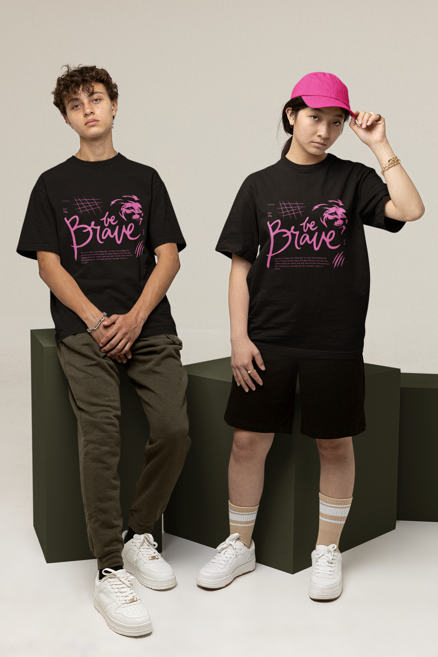 A boy and girl wearing matching black oversized T-shirts with the bold 'Be Brave' text and lion logo on the front, embodying motivational streetwear style by Looma Fashion.