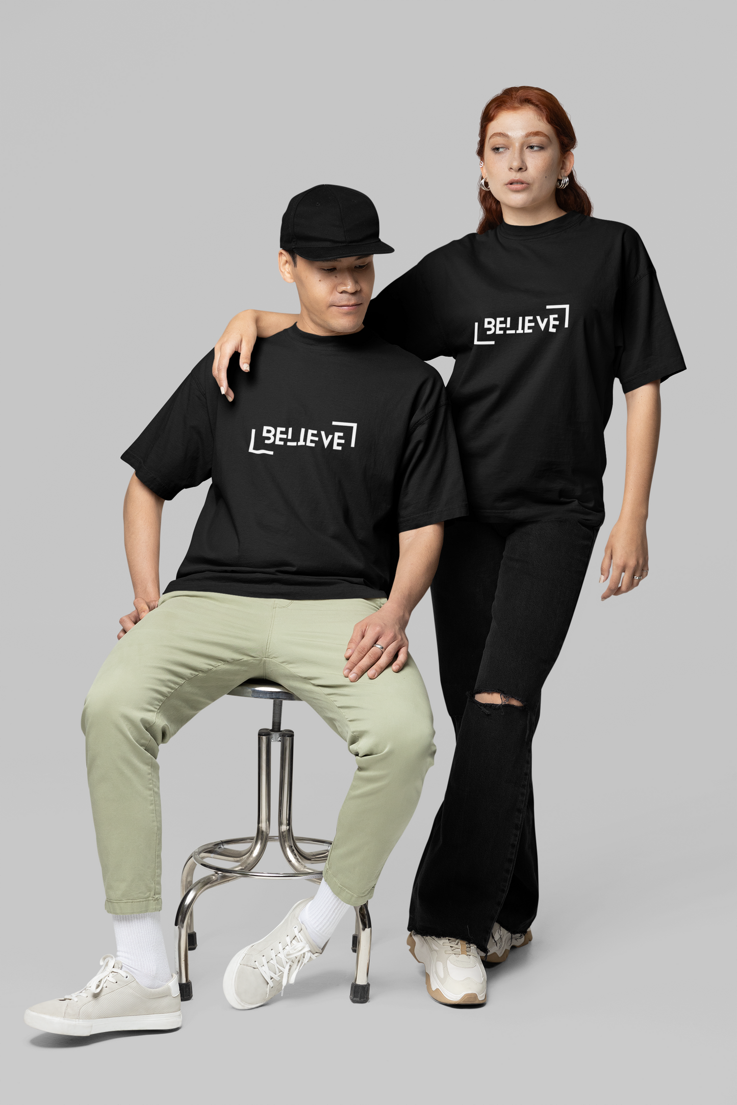 A couple dressed in matching black oversized T-shirts with minimalist front designs, perfect for casual outings and stylish pair looks