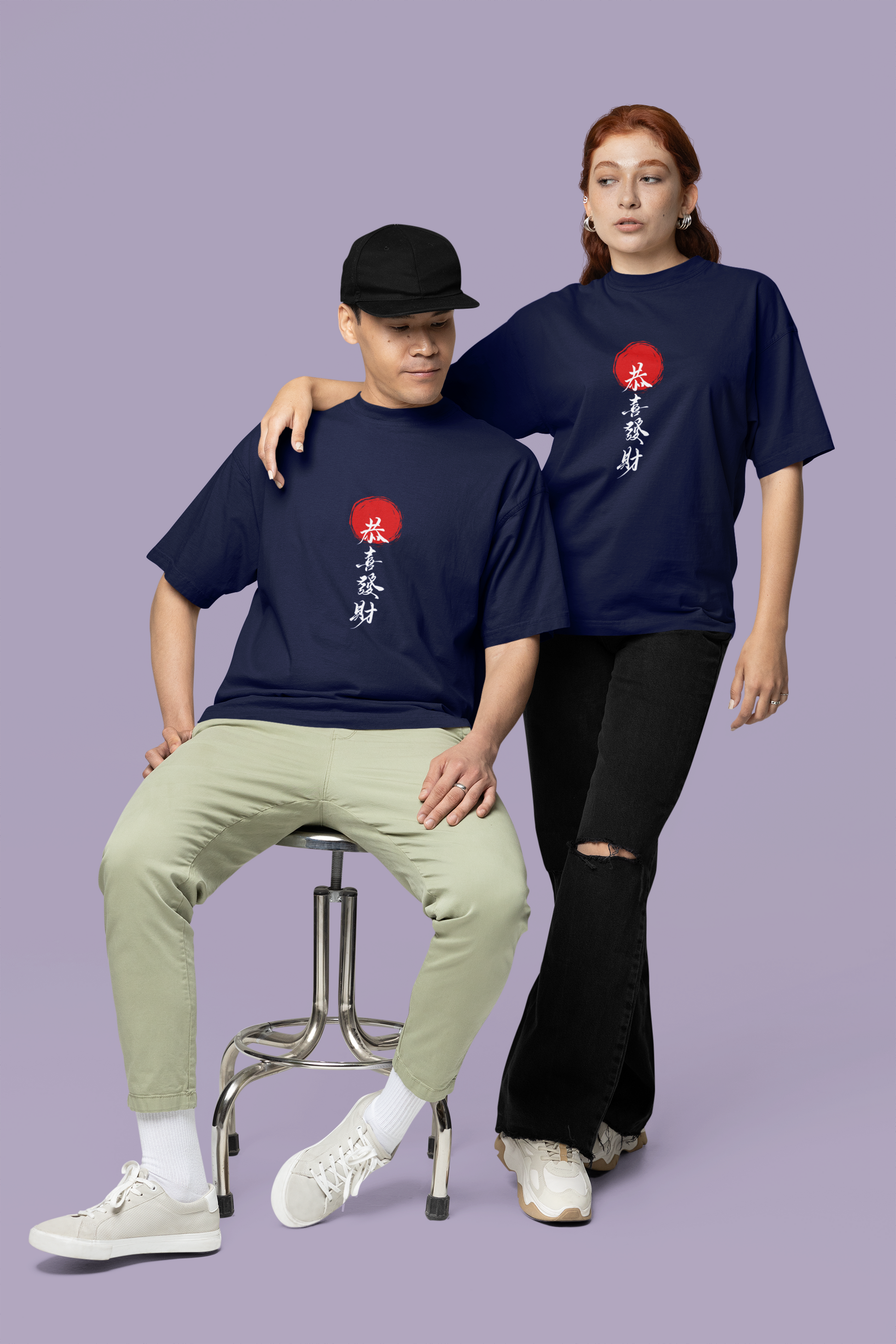 A couple wearing navy blue oversized T-shirts featuring detailed Chinese typography on the front, ideal for trendy and coordinated urban fashion