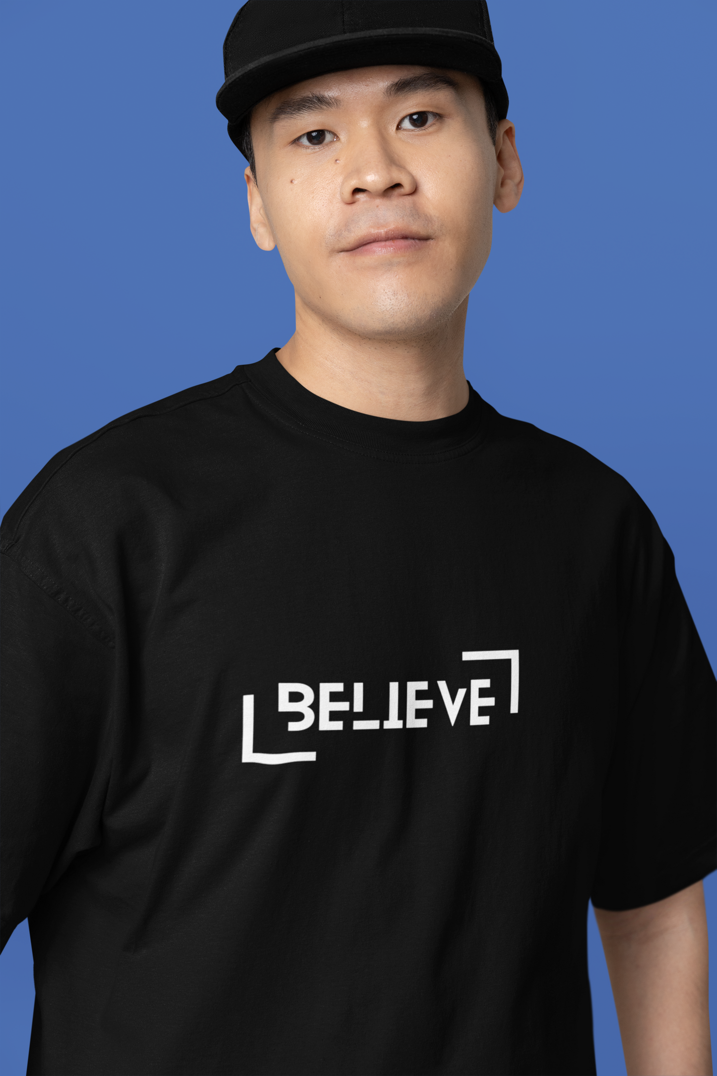 A solo man wearing a black oversized T-shirt with a minimalist front design, perfect for casual and trendy streetwear looks.